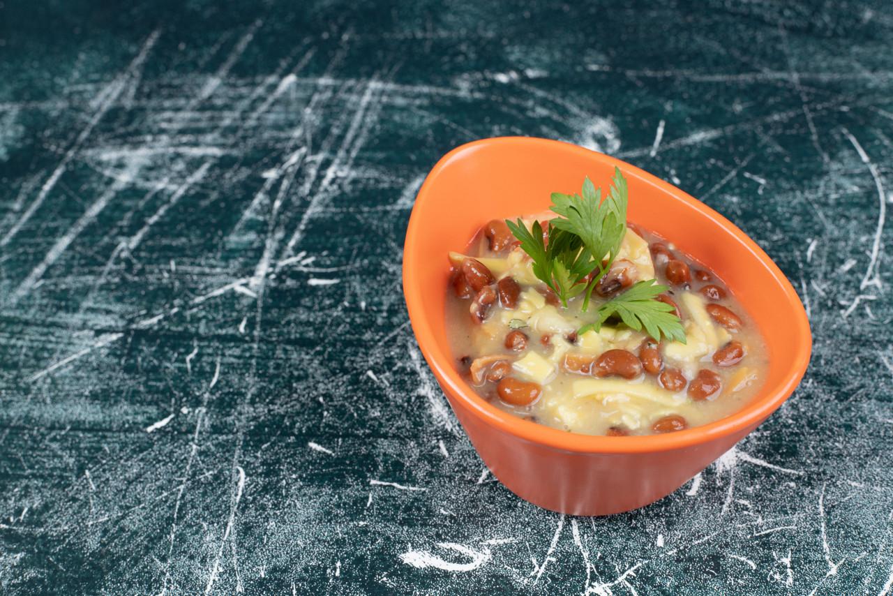 bowl delicious soup with pasta beans blue background high quality photo